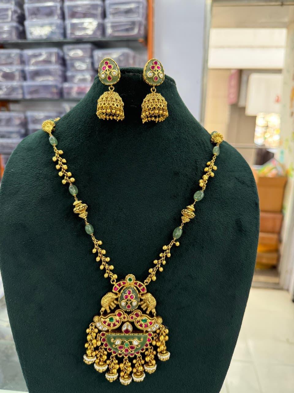 Antique Gold Finish Kundan Pendant Necklace Set with Jhumka Earrings – Green & Ruby Enamel